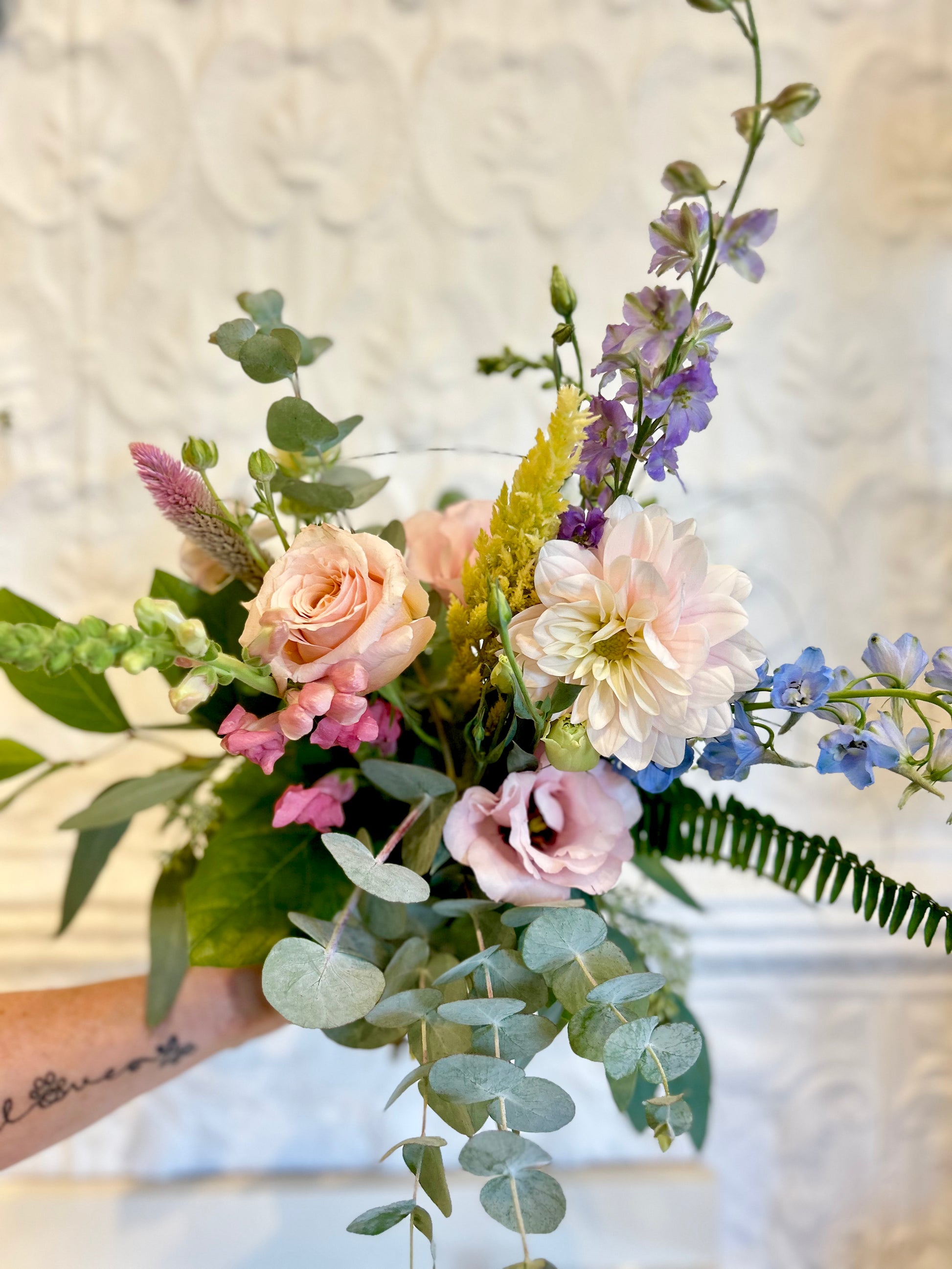 Bouquet of flowers held by a person with a blurred background